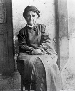 Photo de Camille Claudel, assise sur une chaise, &agrave; l'asile de Montdevergues