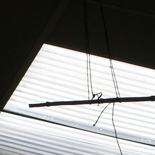 ficelle et morceau de bois, suspendus dans l'atelier sous l'une des ouverures du plafond